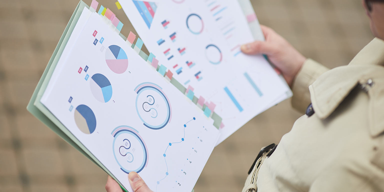 femme qui tient des documents représentant des analyses d'inscription à un webinaire