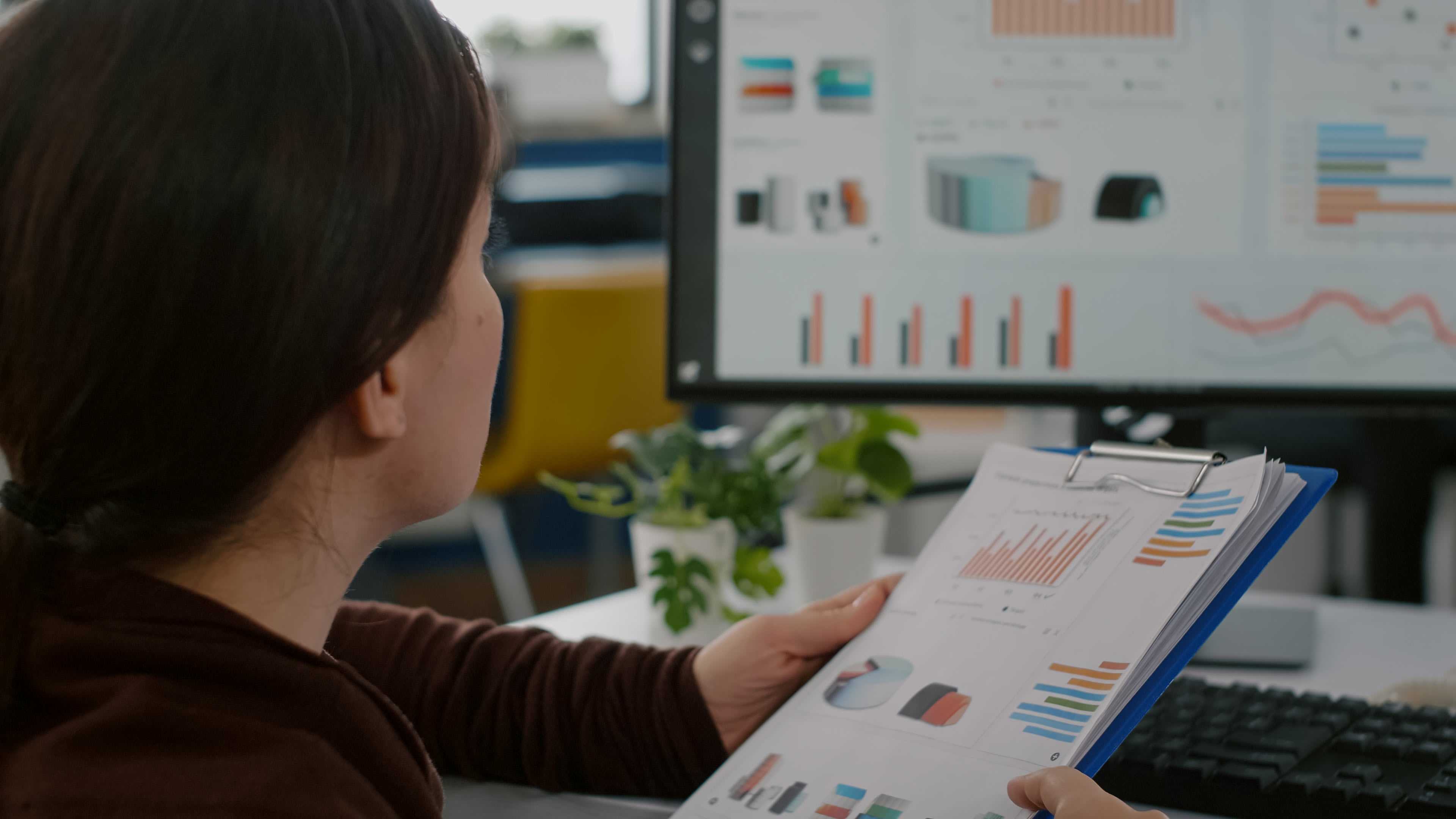 Une femme qui analyse un incident qui a eu lieu dans un webinaire - devant un écran d'ordinateur avec des graphiques de mesure