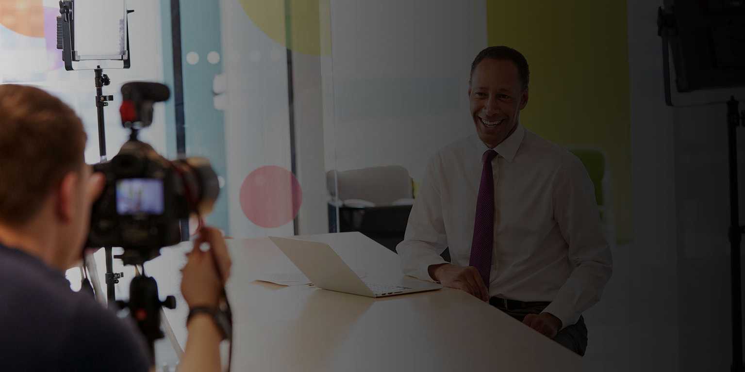 homme de business qui fait un webinaire en ligne pour son entreprise : homme de race noir, homme de race blanche sur un table