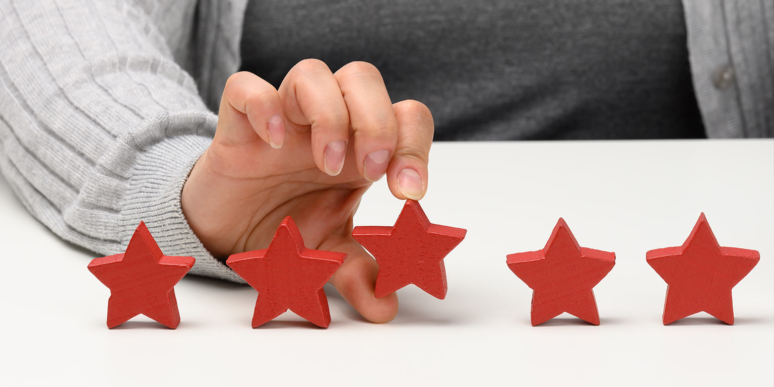 représentation de feedback - main qui tient des étoiles rouges