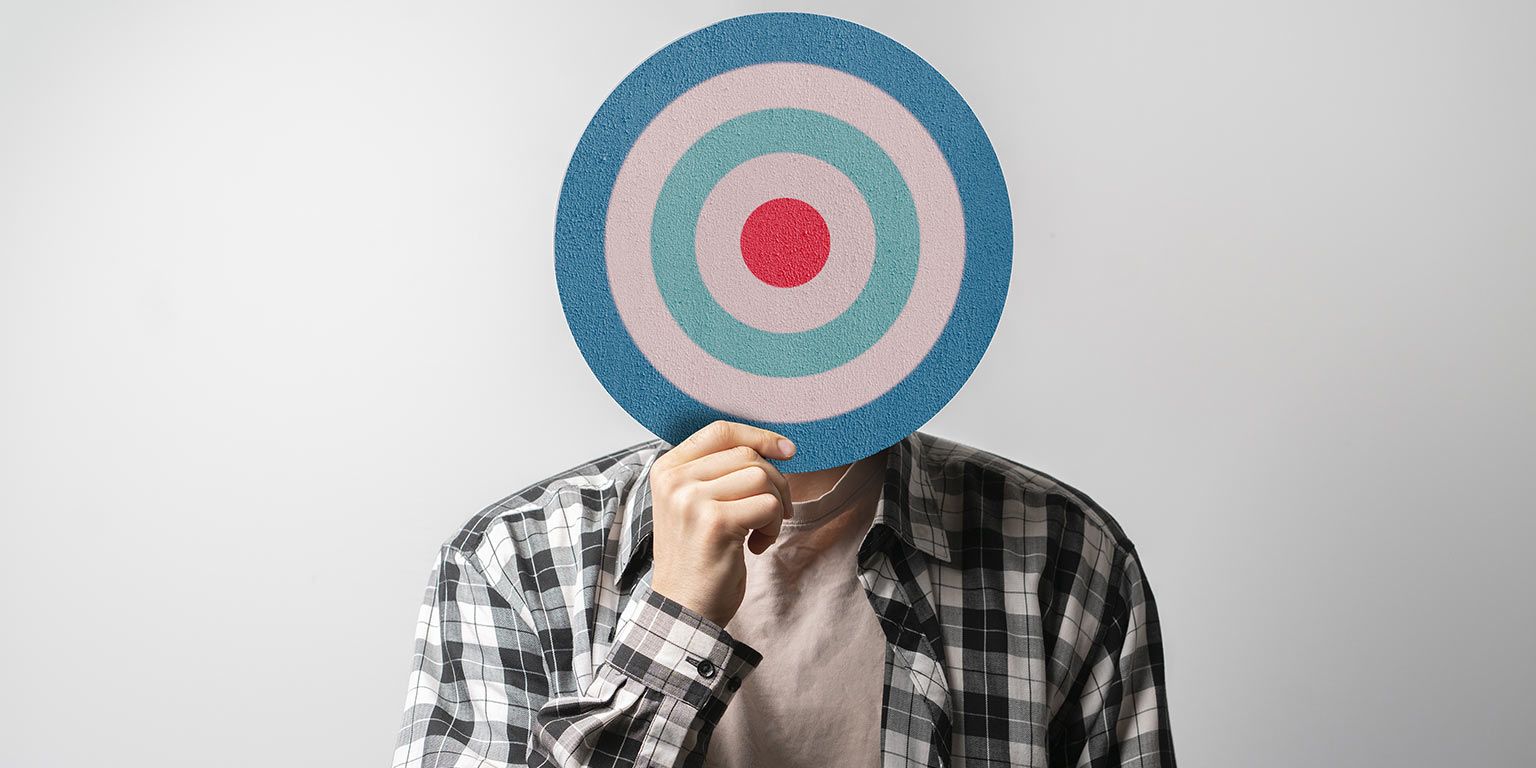 personne qui tient une mir (type bull's eye) qui couvre sont visage pour rappeler comment il est crucial de mesurer la performance d'un webinaire