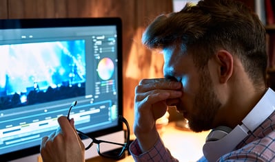 Fatigue visuelle et lumière bleue - les solutions. Image qui représente un homme épuisée en avant de son laptop avec un background d'écran. 