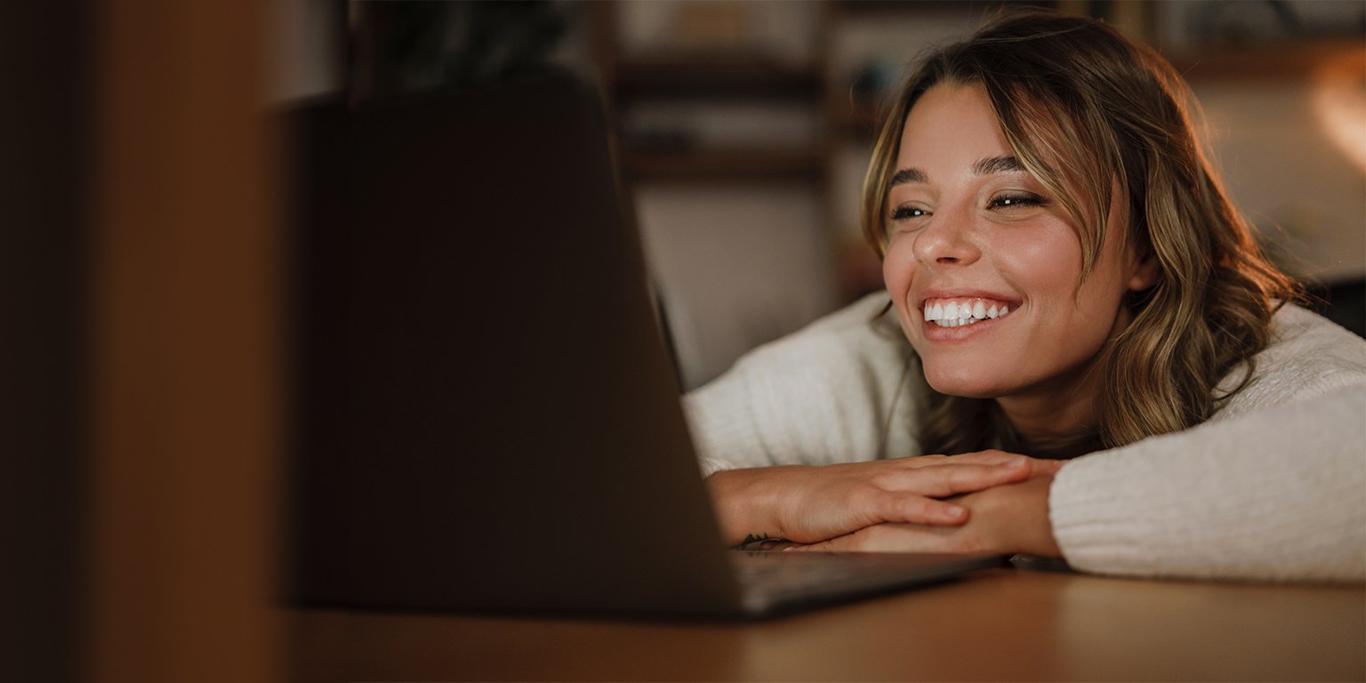 Jeune femme qui sourit en étant sur une bonne plateforme de webdiffusion